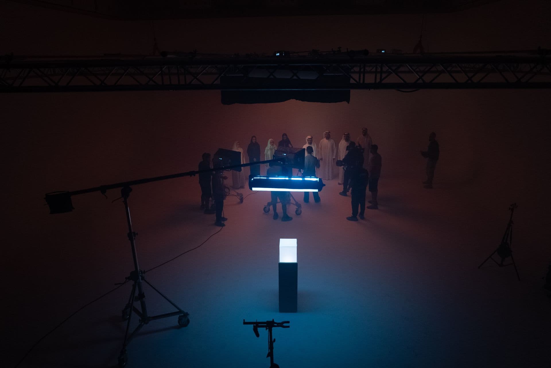 A dark studio with columns of light and a crew at work